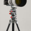 A camera with a large white and black telephoto lens mounted on ROGETI RG-1 Gear head, GZA panning head and T32 Lite Plus tripod. 